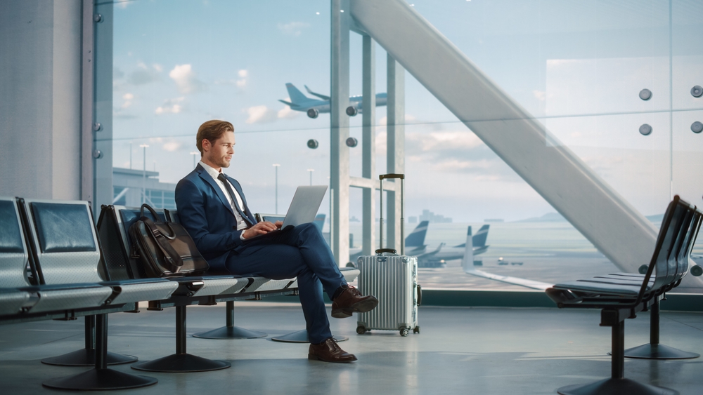 A businessman working on his laptop at the airport